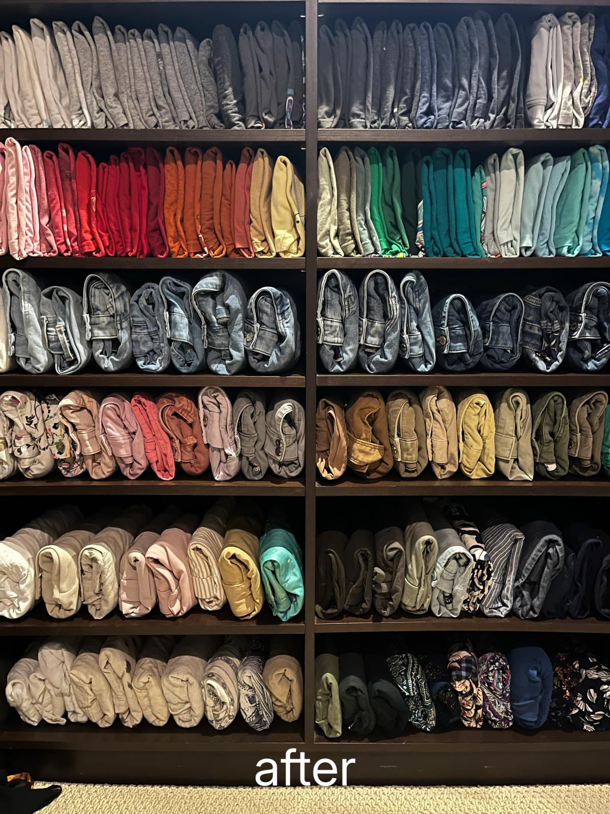 The same shelving unit with every garment rolled, stood upright and grouped by colour across six shelves.
